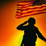 US soldier saluting and honoring fallen heroes
